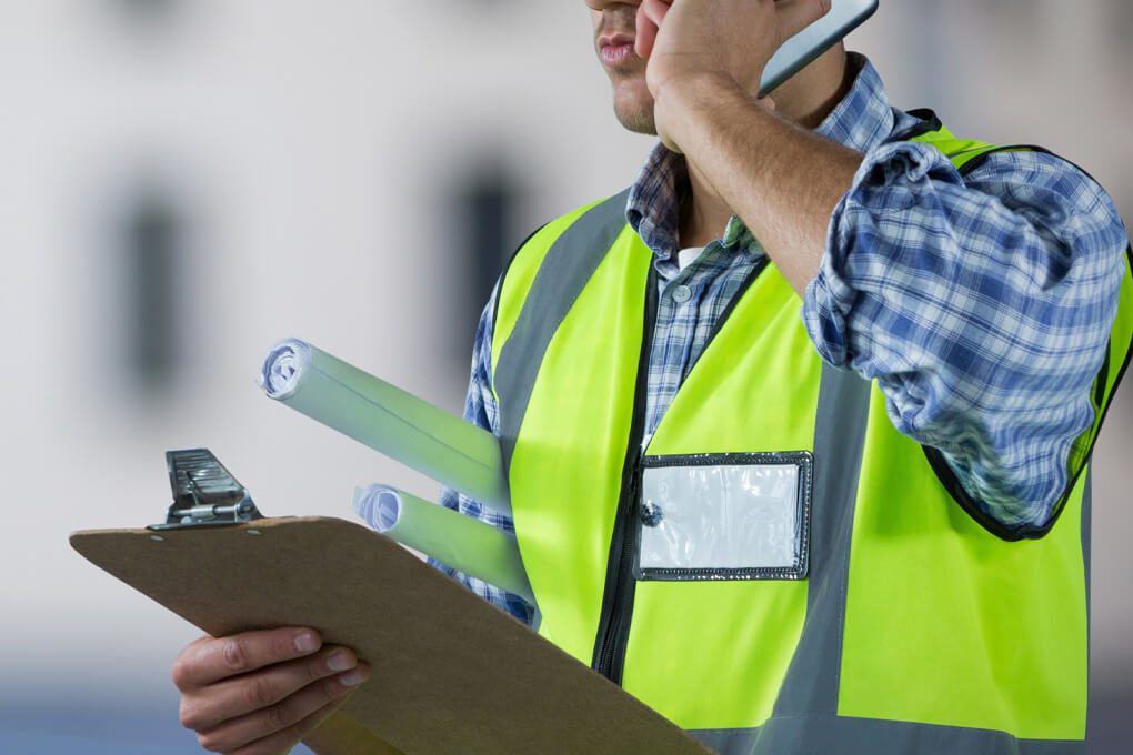 Subcontractor with Clipboard, and plans, on the phone