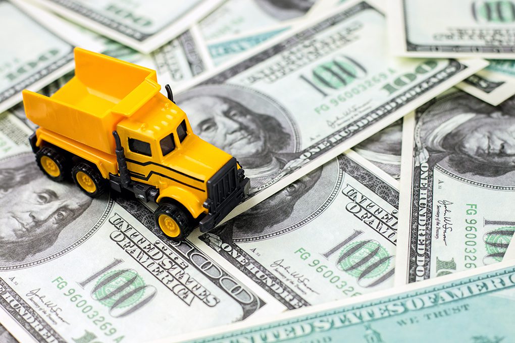 Toy Dump Truck Running Over $100 Bills