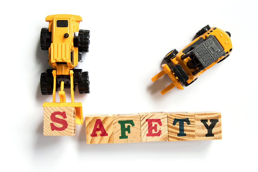 Toy Construction Equipment Moving Letter Blocks to Spell the Word, "Safety"
