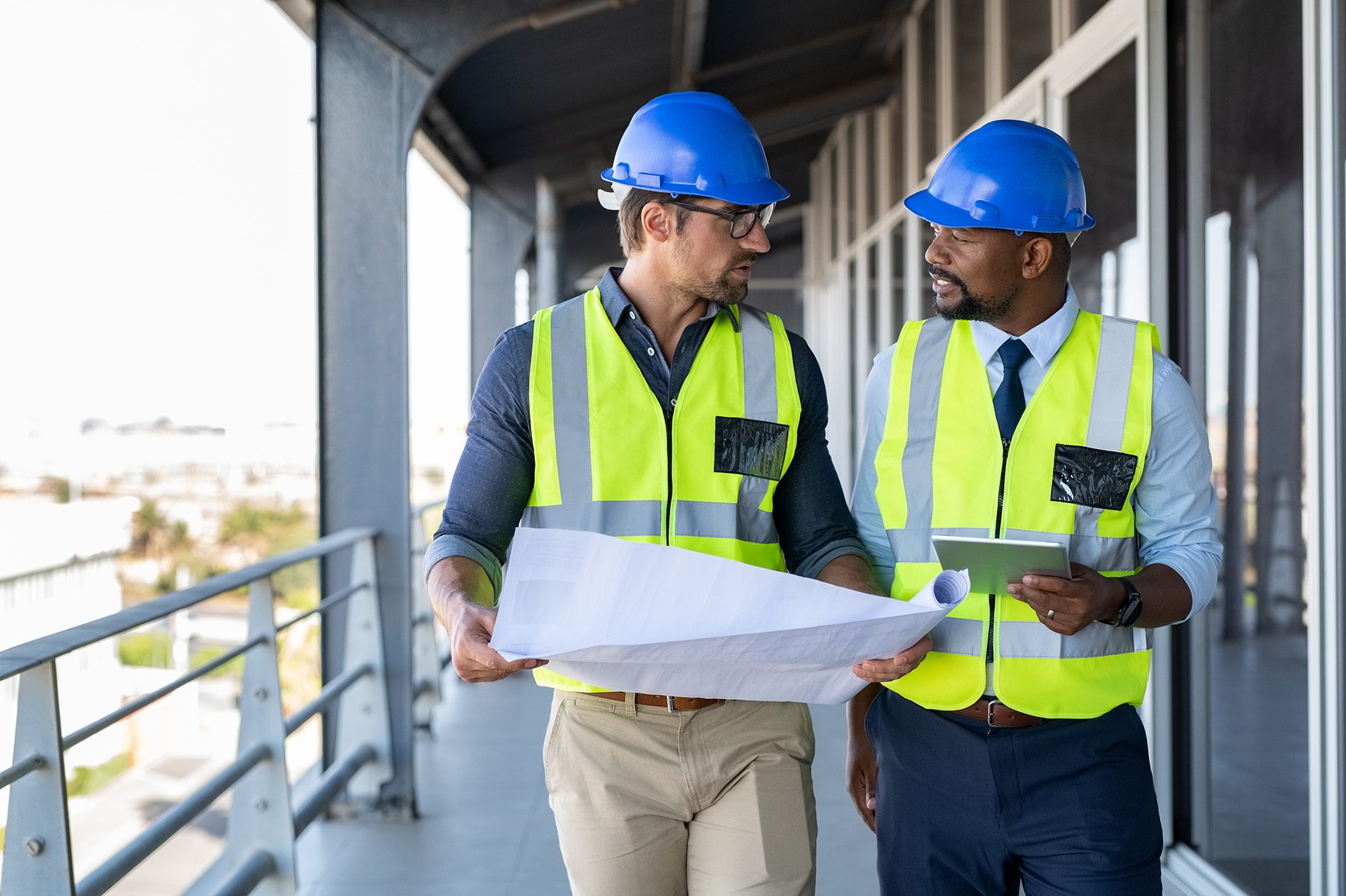 Two construction workers in hard hats looking at plans